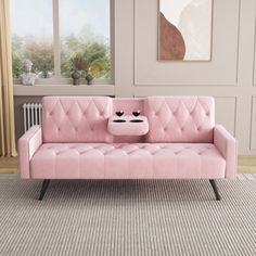 a pink couch sitting on top of a carpeted floor