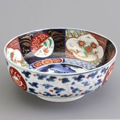 a colorful bowl with designs on the inside and outside, sitting on a gray surface