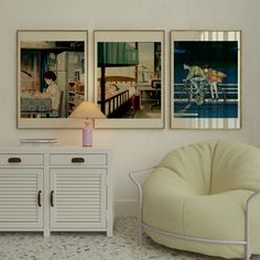 two pictures hang on the wall next to a white cabinet and chair with a lamp