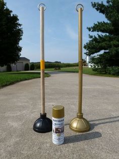 two metal and wood poles are standing next to each other on the pavement in front of some trees