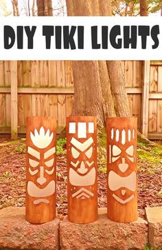 three wooden tiki lights sitting next to a tree