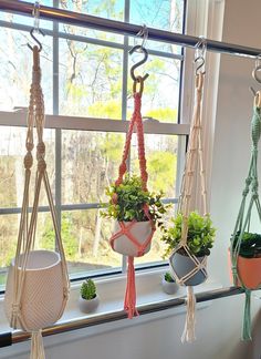 three hanging planters in front of a window