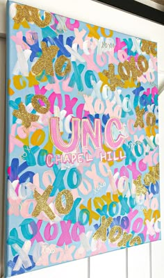 a sign that says unc chapel hill in gold and pink letters on blue background