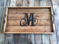 a wooden tray with the letter m on it and a black monogrammed initial