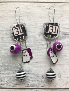 Here we have a spooktacular pair of handmade Halloween mixed media collage earrings.  They are made from salvaged metal, beads, patterned paper, and polymer clay.   These earrings are a little over 3.5" long. All my earrings are one-of-a-kind as I couldn't duplicate them even if I wanted to (I've tried and it never works quite the same)!  So enjoy these unique pieces. Handmade Spooky Earrings For Gift, Quirky Handmade Halloween Jewelry, Collage Earrings, Handmade Black Halloween Earrings, Whimsical Handmade Halloween Earrings, Quirky Halloween Earrings, Eyeball Earrings, Halloween Collage, Purple Halloween