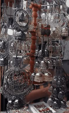 an assortment of silver jewelry on display in a store