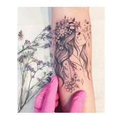 a woman's arm with flowers and butterflies on it, next to a pink glove