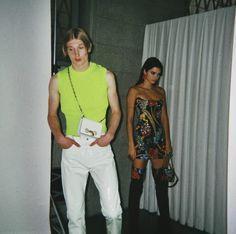 two people standing next to each other wearing white pants