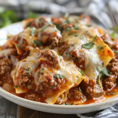 a white plate topped with lasagna covered in meat and cheese