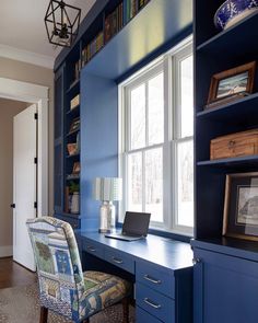 a desk and chair in a room with blue bookshelves