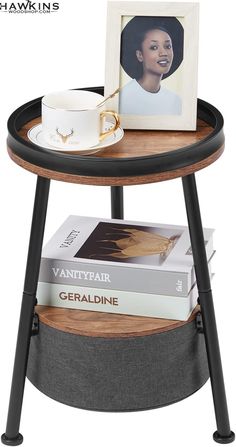 a wooden table with two books and a cup on it next to a framed photo