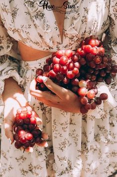 the woman is holding grapes in her hands