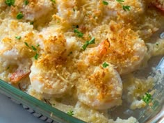 a casserole dish with shrimp and parmesan bread crumbs on top