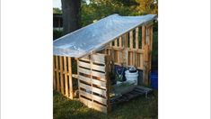 a wooden structure with a tarp over it and some tools in the back ground