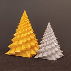 two origami christmas trees sitting next to each other