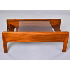 a wooden coffee table with glass top on white background and no one in the photo