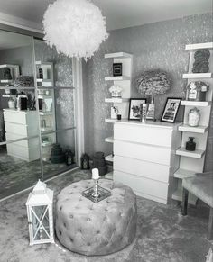 black and white photo of a living room with a large ottoman in front of the mirror