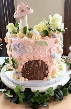 a pink cake decorated with flowers and mushrooms