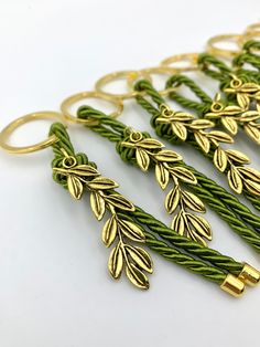 green and gold braided bracelets with leaves on the ends, set against a white background