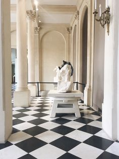 a white bench sitting on top of a black and white checkerboard tile floor