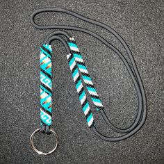 a blue and white lanyard with a metal ring on it's end sitting on a gray surface