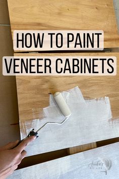 a person using a paint roller on top of a piece of wood with the words how to paint veneer cabinets