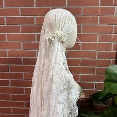 a mannequin wearing a white veil with flowers on it