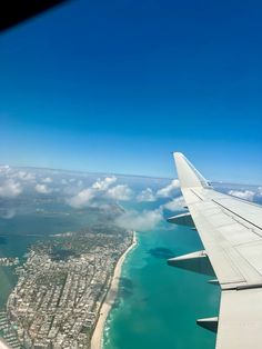 an airplane wing is flying over the ocean