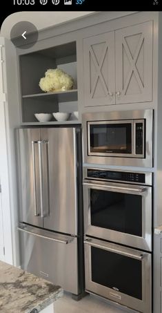 a kitchen with stainless steel appliances and built - in shelving unit for the oven