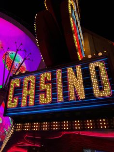 a casino sign lit up at night with neon lights