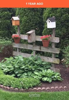 a wooden fence with flowers and plants growing on it in the middle of a garden