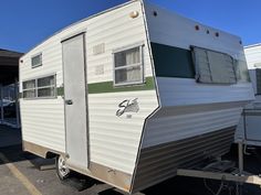 an rv parked in a parking lot next to another trailer with windows on the side