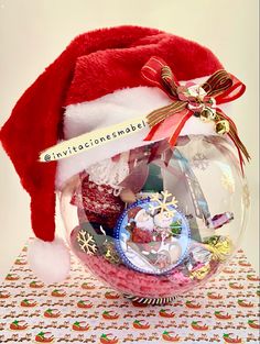 a christmas ornament with santa's hat and other items in it on a table