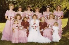 a group of women in pink dresses standing next to each other on the grass near trees