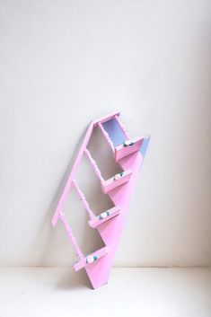 a pink shelf sitting on top of a white table