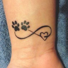 a dog paw and heart tattoo on the wrist