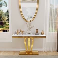 a white and gold console table with various items on it in front of a window