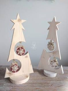 three wooden christmas trees with ornaments in them