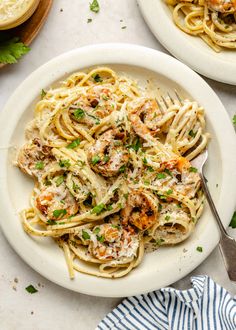 two plates of pasta with shrimp and parsley