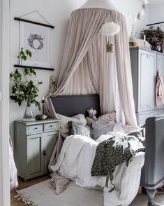 a canopy bed in a bedroom with white walls