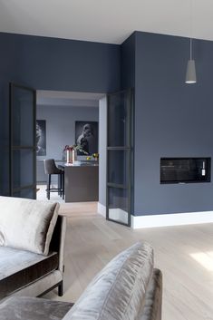 a living room filled with furniture and a fire place next to a wall mounted tv