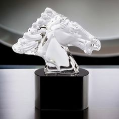 a clear glass horse head on a black base