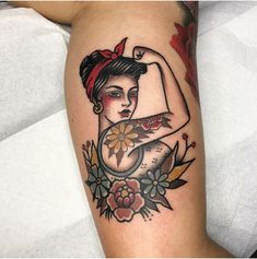 a woman's arm with a tattoo on it and flowers around the arm area