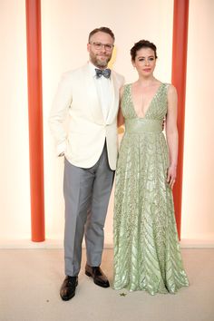 a man and woman in formal wear standing next to each other on a carpeted floor