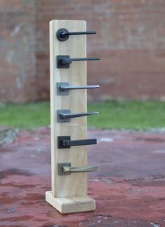 a wooden rack with six knives on it and four hooks attached to the back wall