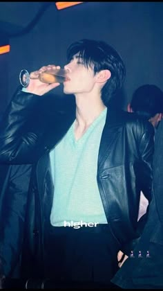 a man in a leather jacket drinking from a bottle