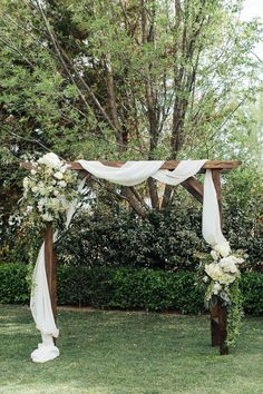 an outdoor wedding setup with white flowers and greenery