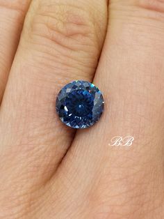 a blue diamond sitting on top of a person's hand with it's fingers