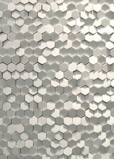 a white tiled wall with hexagonal tiles on it