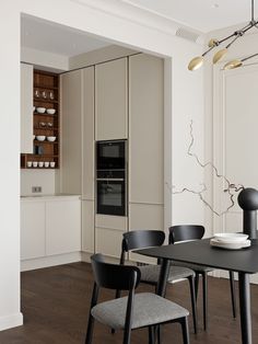 a dining room table and chairs in front of a wall with shelves on each side